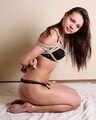 Barefoot Flexygirl in bikini, tied with hemp rope, poses and wiggles on the floor