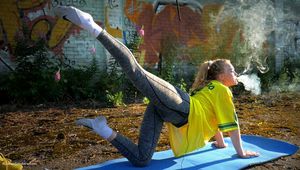 Anastasia is doing some fitness and stretching while smoking outdoors