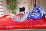 Sonja tied, gagged and hooded on bed with cuffs wearing a sexy grey shiny nylon rain pants and a blue down jacket (Pics)
