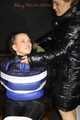 Sexy Mara wearing a black rain pants and a blue/black down jacket being tied, gagged and hooded with tape and clothgag (Pics)