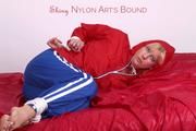 Pia tied and gagged on bed in a shiny bluerainpants and red rainjackert (Pics)