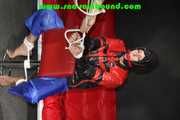 Sexy PIA wearing a sexy blue rainbib and a black/red shiny nylon rainjacket being tied, gagged and hooded on a chair with ropes and a ballgag (Pics)