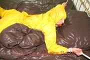 Stella tied and gagged on a bed wearing a supersexy yellow rainwear combination (Pics)