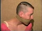 PUNK GIRL MELA IS WRAP TAPE GAGGED, BAREFOOT, TOE-TIED & BALL-TIED ON THE BED (D46-15)