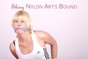 Pia tied and gagged on bed wearing a shiny darkblue nylon shorts with red stripes and white shirt (Pics)