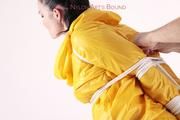 Jill tied and gagged in a shiny yellow rainsuit and rubber boots