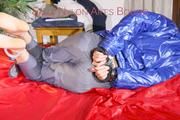 Sonja tied, gagged and hooded on bed with cuffs wearing a sexy grey shiny nylon rain pants and a blue down jacket (Pics)