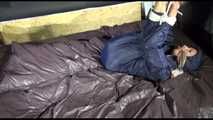 Sexy Sandra wearing a sexy blue shiny nylon pants and a sexy blue rain jacket tied and gagged with ropes and a cloth gag on a bed (Video)