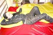 Lucy preparing her bed and enjoys it wearing sexy black rainwear (Pics)