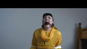 Jill tied and gagged on a chair wearing a yellow rainsuit and coveres with an yellow raincoat with two hoods (Video)