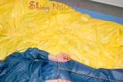 Alina wearing a sexy shiny rainwear suit in blue lolling on bed cuffed (Pics)