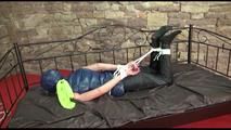 Pia tied and gagged on a princess bed in an old cellar wearing a sexy black rain pants and a darkblue/green down jacket (Video)