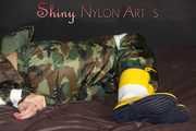 Sexy PIA being tied and gagged with tape and a clothgag on the sofa wearing a camouflage rainsuit and yellow rubber boots (Pics)