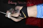 Watching ***NEW MODELL COURTNEY*** wearing a sexy lightblue shiny nylon shorts and a black top being tied and gagged overhead with ropes and a ballgag (Pics)
