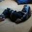 One of our archive girl tied, hooded and gagged by tape on a bed wearing shiny nylon rainwear (Video)