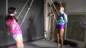 Aiyana and Ms Ungeniert in shiny nylon Shorts and Windbreaker tied and gagged together