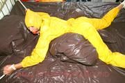 Stella tied and gagged on a bed wearing a supersexy yellow rainwear combination (Pics)