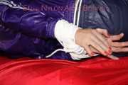 Sexy Pia being tied and gagged with ropes and a clothgag on a bed wearing a sexy darkblue shiny nylon shorts and a sexy blue/purple rain jacket (Pics)
