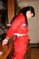 Jill bound in a red nylon rainsuit