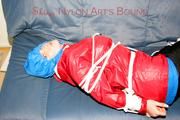 Jill tied, gagged and hooded on the sofa wearing a sexy black shiny nylon pants and two rain jackets (Pics)