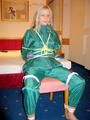 Blonde archive girl tied and gagged in an green shiny nylon rainsuit on a chair (Pics)