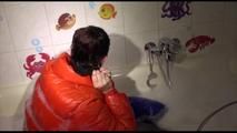 Jill ties and gagges herself in a bath tub for having an extraordinary experience wearing a sexy lightblue rainpants and an orange down jacket (Video)