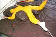 Stella tied and gagged on a bed wearing a supersexy yellow rainwear combination (Pics)