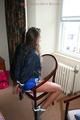 Stella tied and gagged on a chair wearing a blue shiny nylon shorts and a rain jacket (Pics)