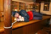 An archive girl tied and gagged on a bar wearing shiny nylon rainwear (Pics)