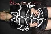 Sophie being tied with ropes in a special way wearing a sexy black shiny nylon shorts and a black shiny nylon rain jacket (Pics)