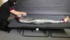 Myxxxy mummyfied in Rainwear struggeling to get free