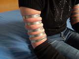 Lea wearing five very tight hose clamps on each arm