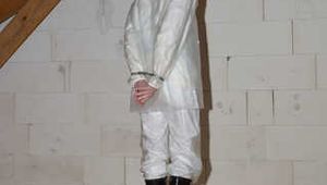 Miss J mit Handschellen gefesselt und streng geknebelt in 2 KWAY Regenanzügen und transparentem Anzug drüber