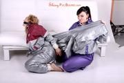 Sophie tied and gagged by Jill on a sofa wearing a shiny silver PVC sauna suit which is slitted by Jill (Pics)