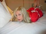 Beautiful archive girl tied and gagged on a bed wearing shiny shorts (Pics)