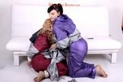 Sophie tied and gagged by Jill on a sofa wearing a shiny silver PVC sauna suit which is slitted by Jill (Pics)