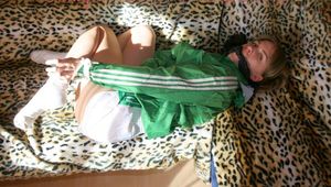 Leonie tied and gagged on a sofa wearing a white shiny nylon shorts and a green rain jacket (Pics)