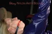 Watching sexy Pia wearing a sexy blue oldschool shiny nylon shorts and a rain jacket being tied and gagged on hands and feet on the ceiling lying on the floor (Pics)