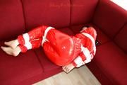 Julia tied and gagged on the sofa in a shiny red PVC Sauna suit (Pics)