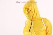 Jill tied and gagged in a shiny yellow rainsuit and rubber boots
