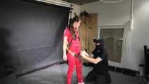 Marie in a custom video suspended in a shiny nylon Jumpsuit