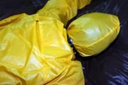 Stella tied and gagged in a shiny yellow rainsuit