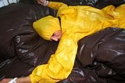 Stella tied and gagged in a shiny yellow rainsuit