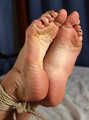 Tapegagged barefoot topless Kim, hogtied with hemp rope, is tickled by the man