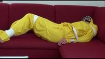 Mara tied and gagged with tape on a sofa wearing a sexy shiny yellow rainwear combination (Video)