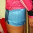 Jessy tied to a pole with blue shorts and a shiny pink jacket