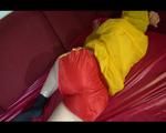 Lucy preparing her sofa with a shiny nylon cloth wearing a sexy red/yellow shiny nylon shorts and a yellow rain jackcet (Video)