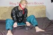 PIA ties and gagges herself with a bar and a cloth gag on a bed wearing a sexy green shiny nylon pants and a black rain jacket (Pics)