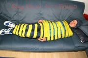Katharina tied and gagged with tape on a sofa wearing shiny rainwear (Pics)
