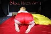 Sexy Sonja posing for you in a red shiny nylon shorts and a tshirts and then she takes it off and plays with the bedding (Pics)